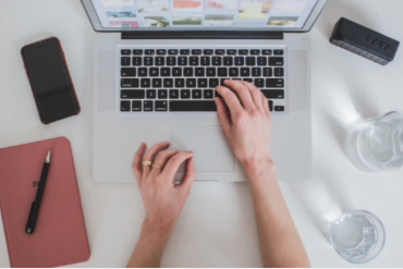 Empreendedor digital focado em computador, criando produto digital com sucesso