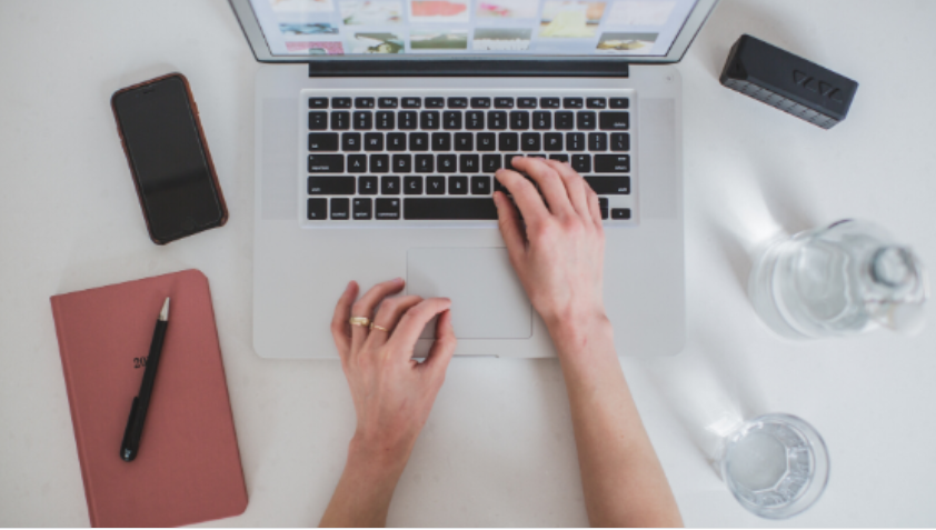 Empreendedor digital focado em computador, criando produto digital com sucesso