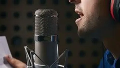 Pessoa cantando com microfone, microfone vintage com pedestal em palco com iluminação dramática, foco nítido no microfone.